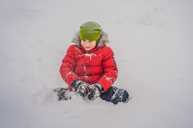 Happy boy plays with snow cute kid throwing snow in a winter park happy winter holidays winter