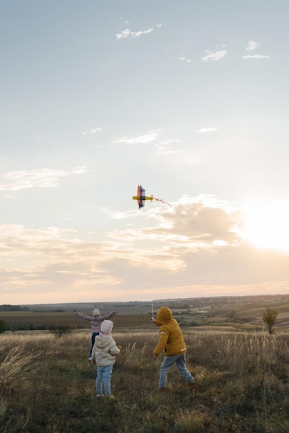 A happy boy with his family flies a kite and spends time together in the fresh air Happy childhood and outdoor recreation with the whole family