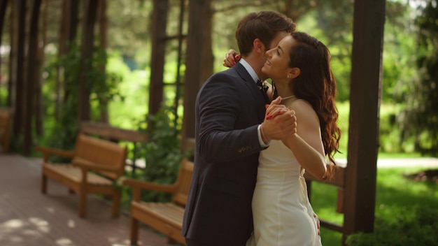 Happy bride and groom celebrating wedding under arch Couple having first dance