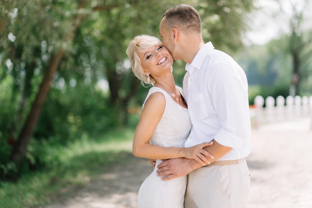 Happy Bride and Groom Embracing Outdoors on Their Wedding Day