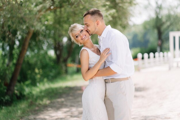 Happy Bride and Groom Embracing Outdoors on Their Wedding Day