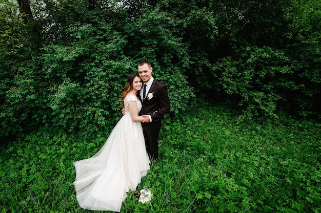 Happy bride and groom getting married in the green forest. Wedding ceremony.