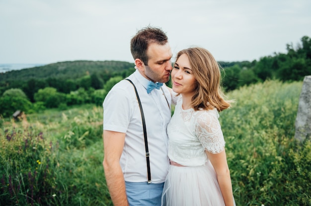 Happy Bride and groom walking on the green grass