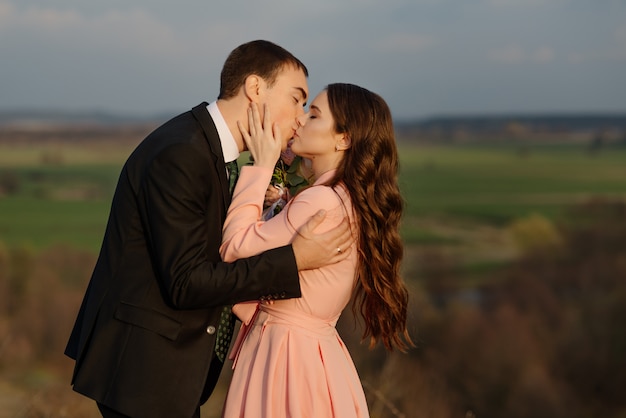 Happy bride and groom walking on a hilly area with a beautiful view.