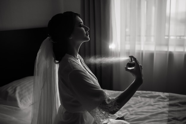 The happy bride splash a perfume. Wedding morning preparation. Bride portrait at wedding morning.