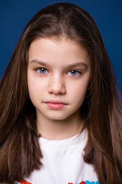 Happy brunette little girl isolated on dark blue background