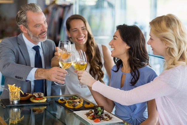 Happy business colleagues toasting beer glasses while having lunch