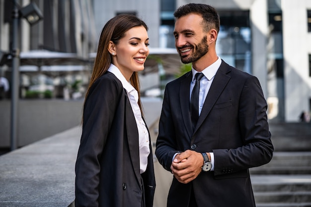 The happy business man and woman standing on the urban background