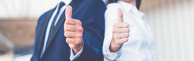 The happy business man and woman thumb up