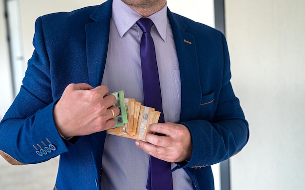 Happy businessman hold euro money after success deal salary or bribe concept