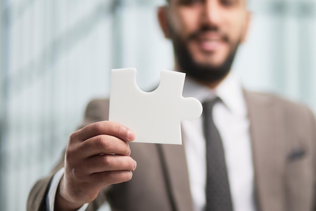 Happy businessman holding a puzzle in his hands Business decisions success and strategy