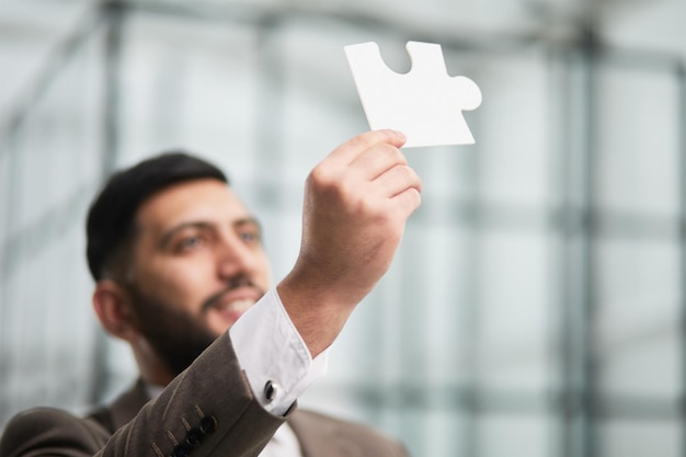 Photo happy businessman holding a puzzle in his hands business decisions success and strategy