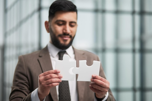 Happy businessman holding a puzzle in his hands Business decisions success and strategy