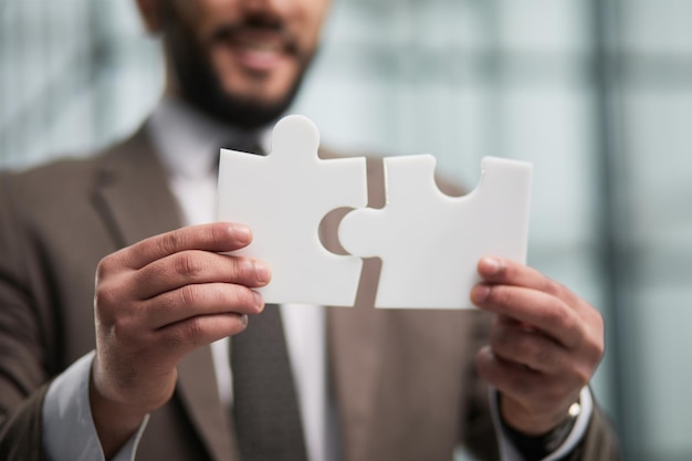 Happy businessman holding a puzzle in his hands Business decisions success and strategy