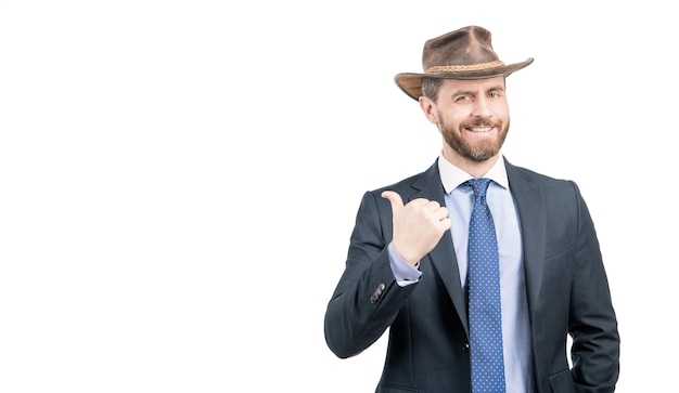 Happy businessman man in cowboy hat and suit smile pointing finger advertising gesture, advertise