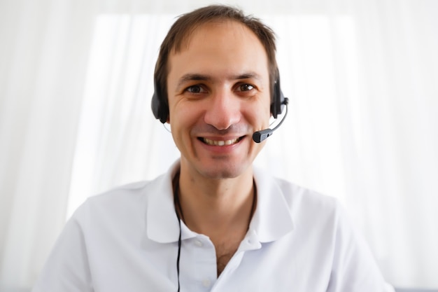 Happy Businessman in the office on the phone, headset, Skype. looking camera