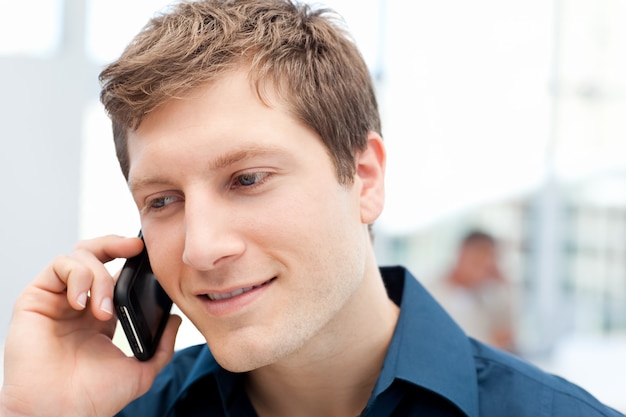 Happy businessman phoning in his office