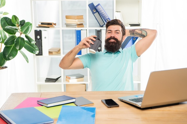 Happy businessman relaxing during coffee break in office relaxation