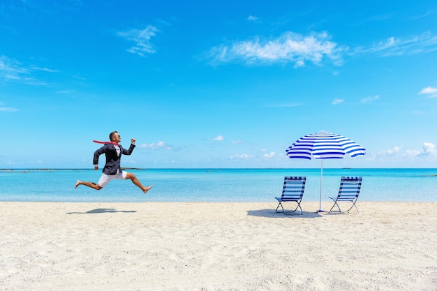 Happy businessman running from the work on the tropical beach Summer vacation concept