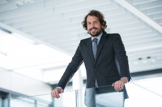 Happy businessman standing in office