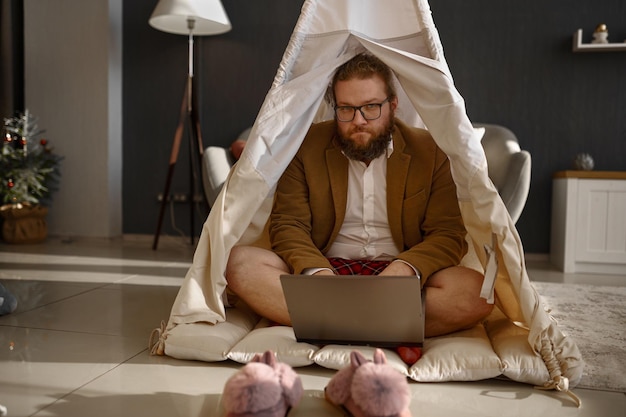 Happy businessman working laptop in home tent