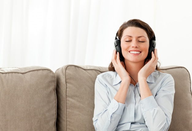 Happy businesswoman listening music with headphones