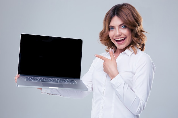 Happy businesswoman pointing finger on laptop screen