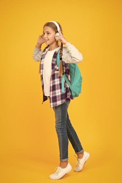 Happy carefree child School classes Student Modern education Energetic cheerful teen listening music Stylish schoolgirl going to school Girl little fashionable girl with backpack School life