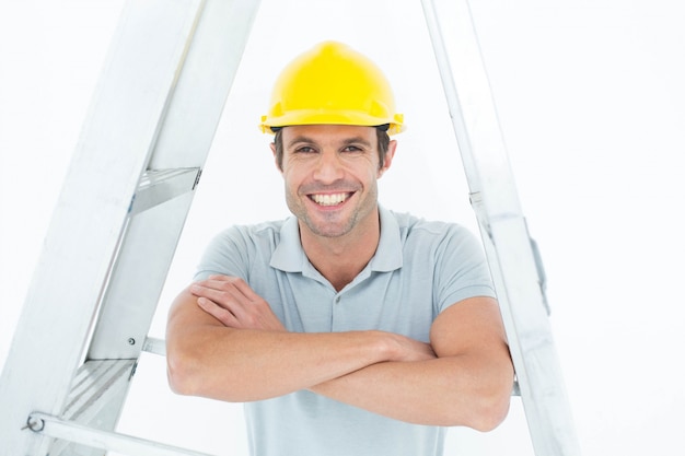 Happy carpenter leaning on step ladder