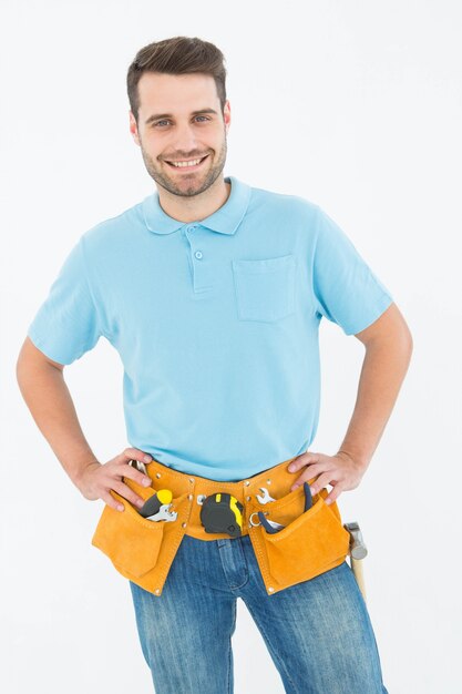 Happy carpenter standing with hands on hips 