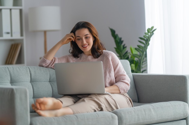 Happy casual beautiful woman using laptop at home