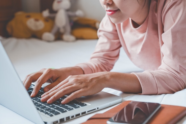 Happy casual beautiful woman working on a laptop and hands typing