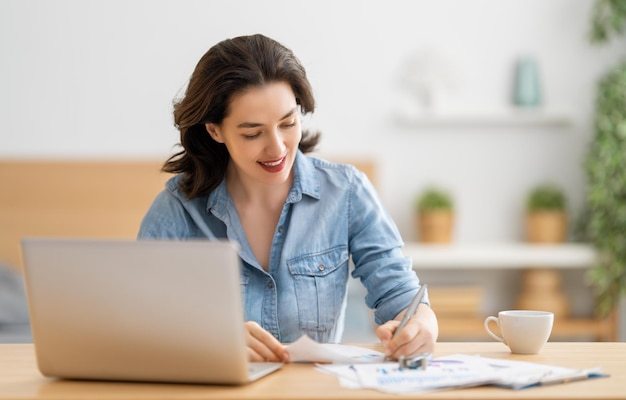 Happy casual beautiful woman working on a laptop at home.