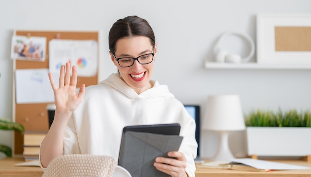 Happy casual beautiful woman working on a tablet pc in home office.