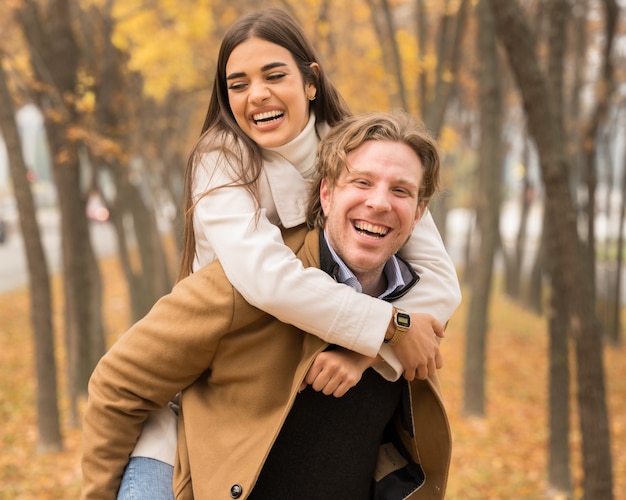 Happy Caucasian couple hugging and smiling in the park in fall