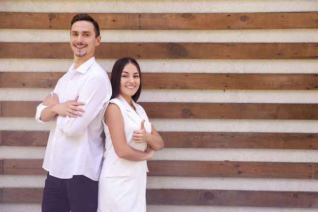 Happy Caucasian man and woman crossing arms showing thumbs up