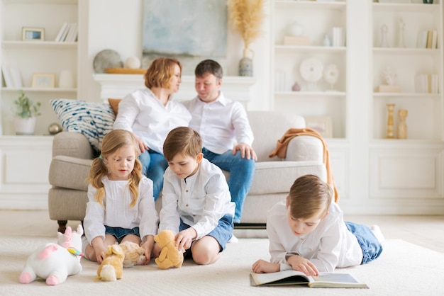 Happy caucasian parents are relaxing on cozy sofa in living room at home small children playing on a