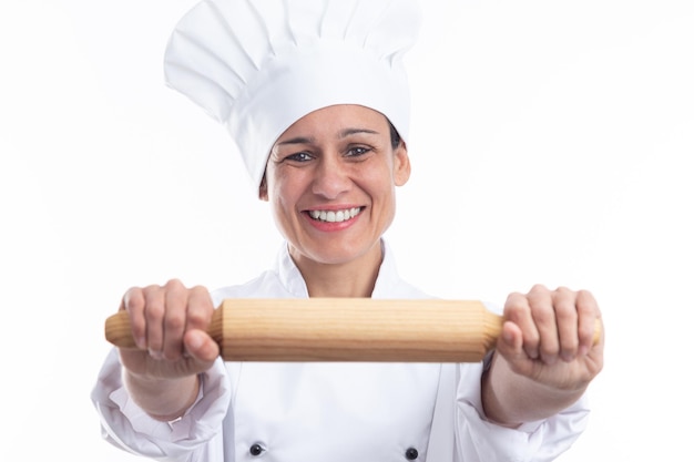 Happy caucasian woman dressed as chef showing kitchen utensil looking at camera isolated on white background