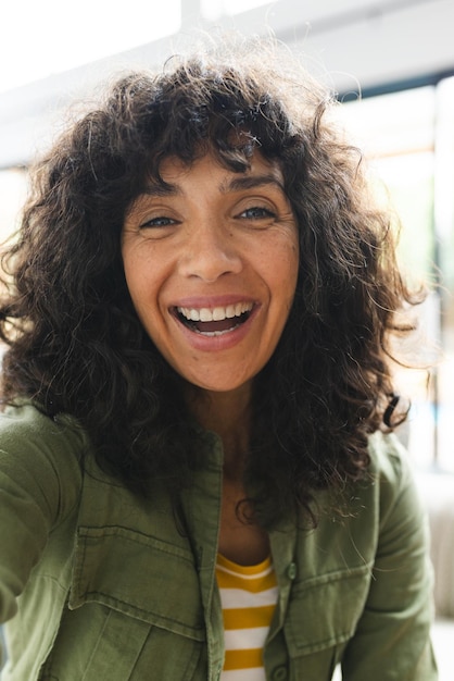 Happy caucasian woman having video call smiling in sunny room at home