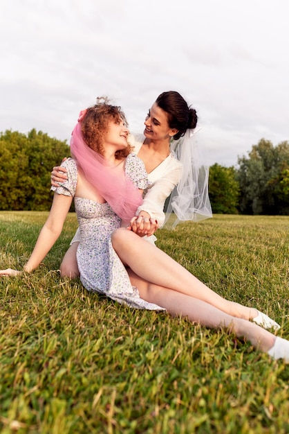 A happy charming bride in a white dress with a white veil and a bridesmaid in a blue dress with a