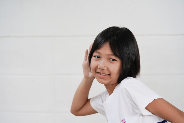 Happy cheerful little girl on white wall with soft light display in fresh morning time