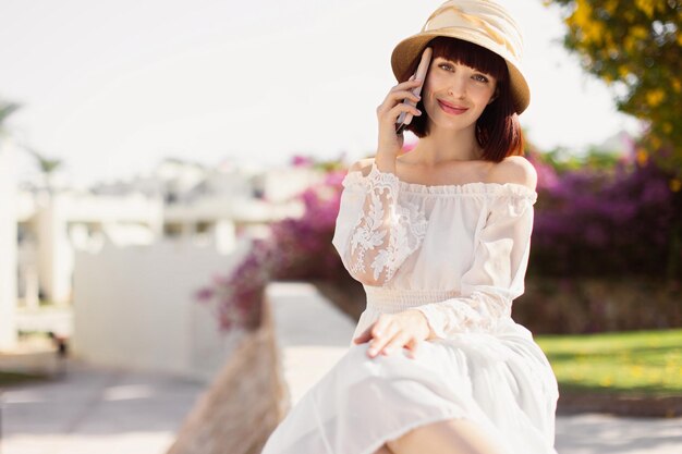 Happy cheerful woman talking on the phone during vacation