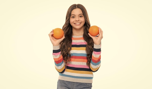 Happy child in colorful sweater with orange fruit isolated on white diet