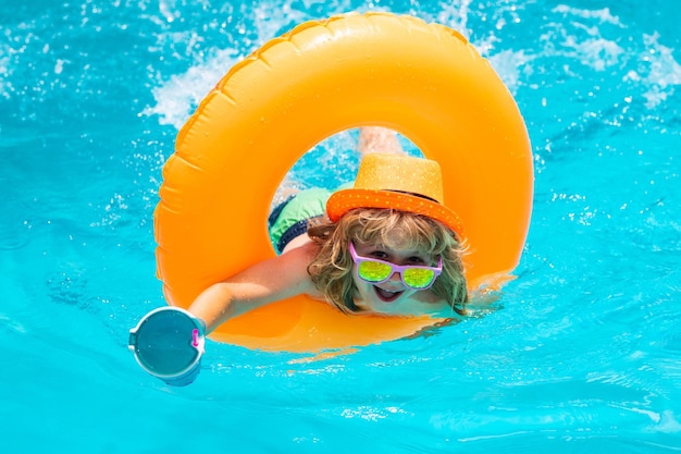 Happy child enjoying summer vacation outdoors in the water in the swimming pool