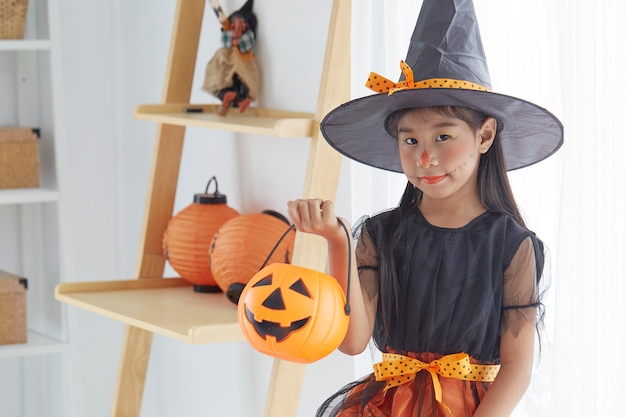 Happy child girl in witch costume to halloween