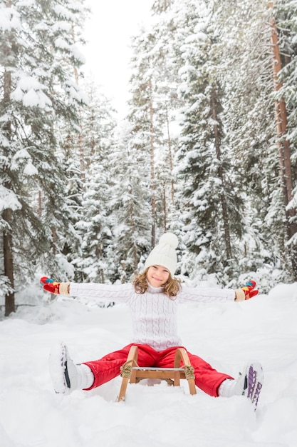 Happy child having fun outdoor. Kid playing in winter time. Active healthy lifestyle concept