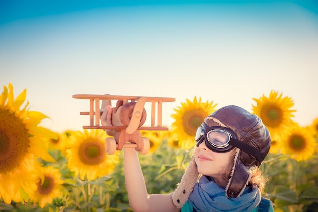 Happy child having fun in spring field against blue sky background Freedom concept