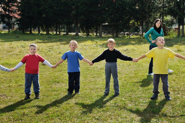 happy child kids group have fun and play at kindergarden outdoor preschool education concept with  teacher