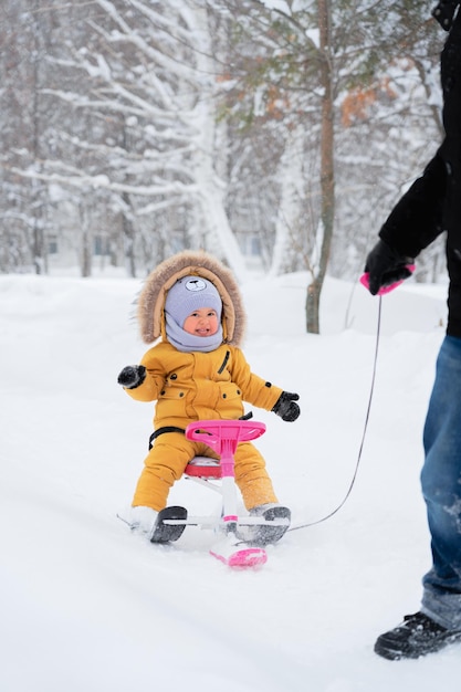 A happy child laughs while riding a childrens snowcat in a winter park