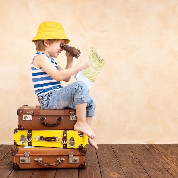 Happy child playing at home. Smiling kid dreaming about summer vacation and travel.